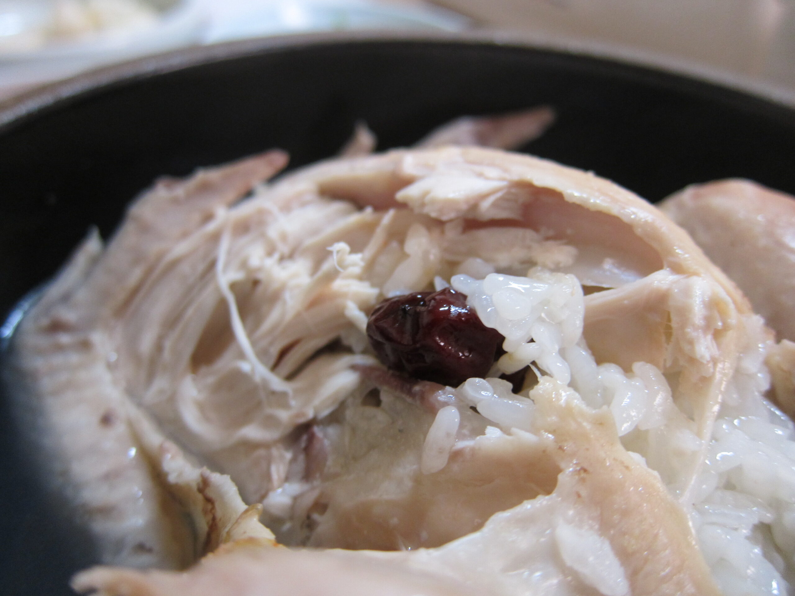Samgyetang chicken opened to show sticky rice and jujubes stuffed inside