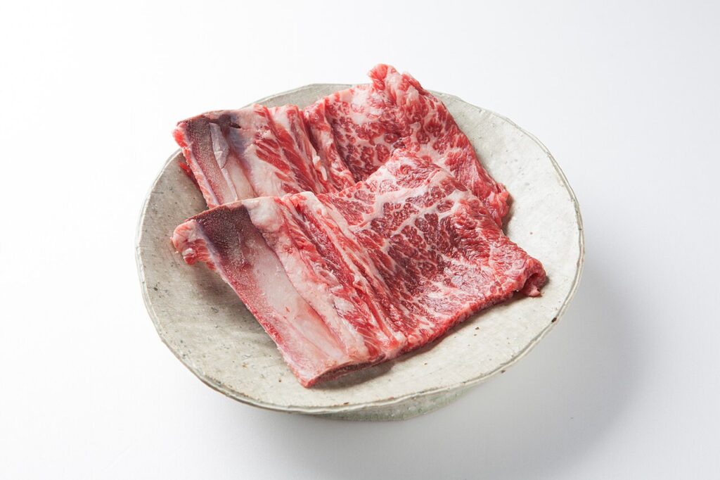 Raw, unmarinated beef short ribs, with the rib bones and meat visible.